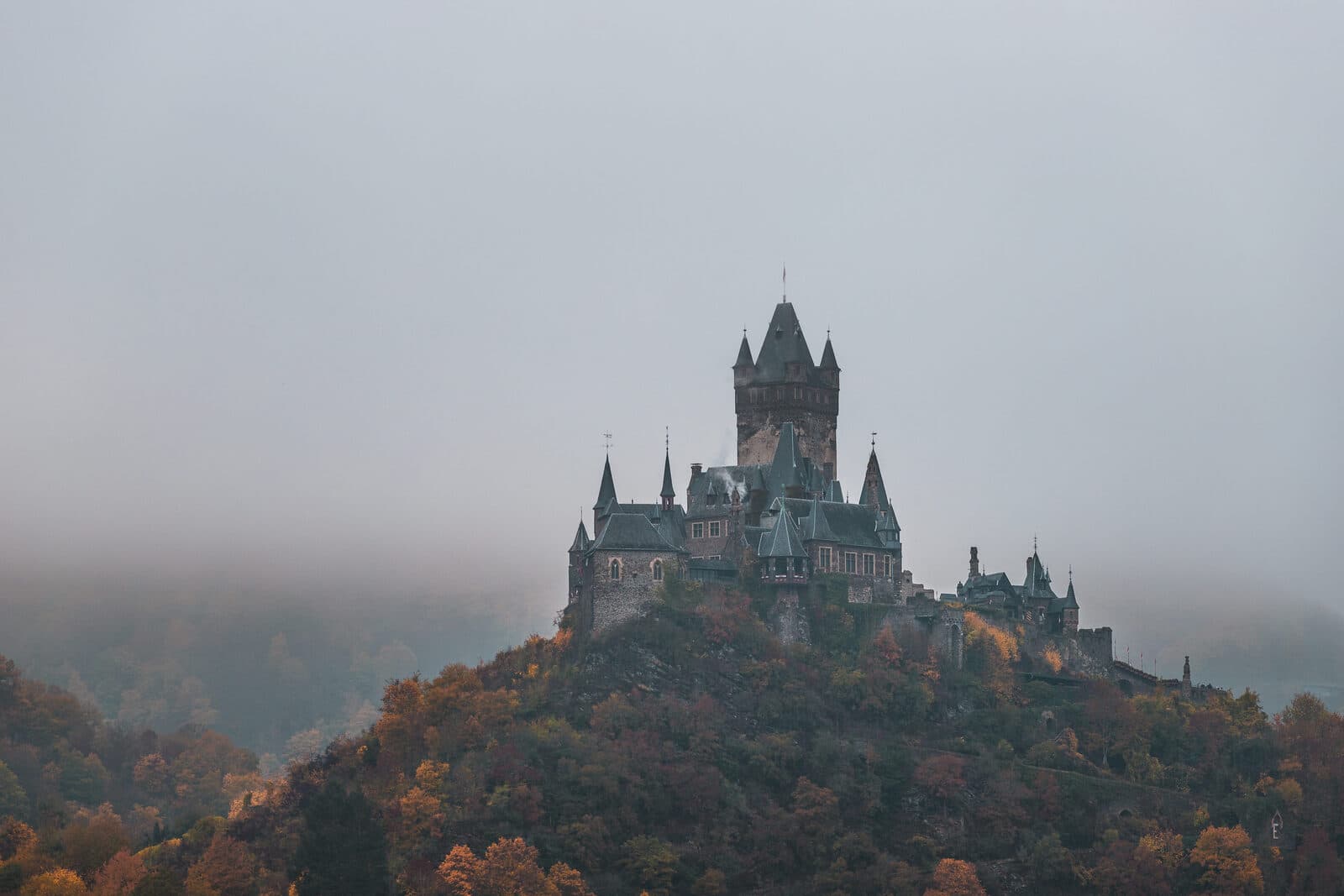 Reichsburg Cochem thront im herbstlichen Nebel hoch über der Mosel